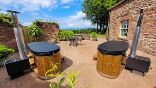 德里门Loch Lomond Finnich Cottages的天井设有双桶和桌椅