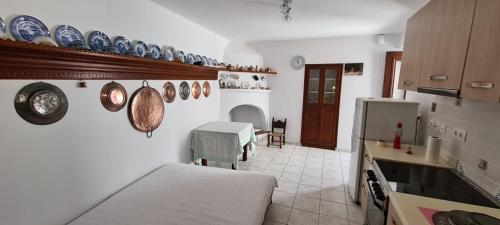 斯基罗斯岛Mini Traditional House的一间设有床铺的房间和一间带壁板的厨房