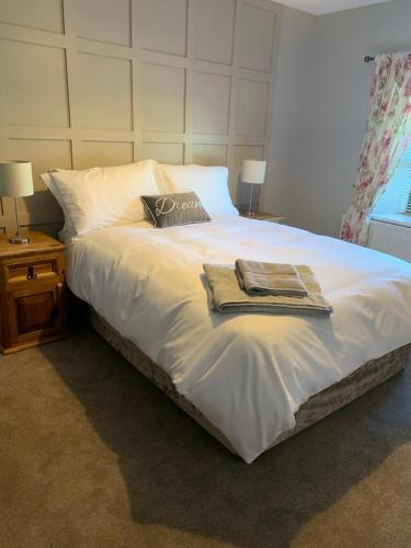 Ó MéithThe Wee House, Omeath的卧室配有一张白色大床和两条毛巾