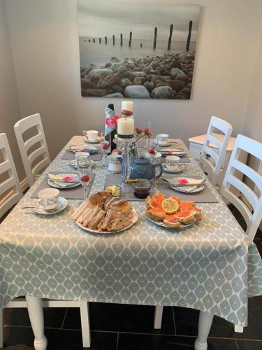 Ó MéithThe Wee House, Omeath的一张桌子,上面有食物和盘子