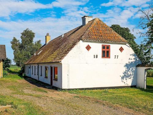 Åbybro12 person holiday home in Aabybro的一座白色的古老建筑,屋顶为棕色