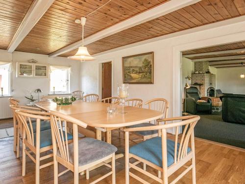 Åbybro12 person holiday home in Aabybro的一间带木桌和椅子的用餐室