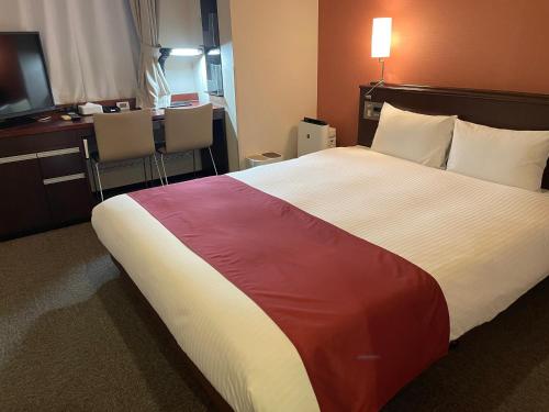 东京Ai Hotel Keikyu Kamata-ekimae的酒店客房设有一张大床和色彩缤纷的毯子