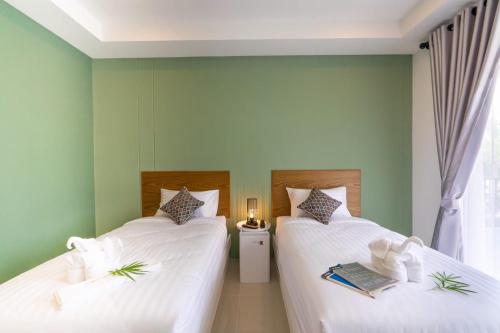 Ban Tongน่านวรรณวัตร รีสอร์ท Nan Wannawat Resort的绿墙客房内的两张床