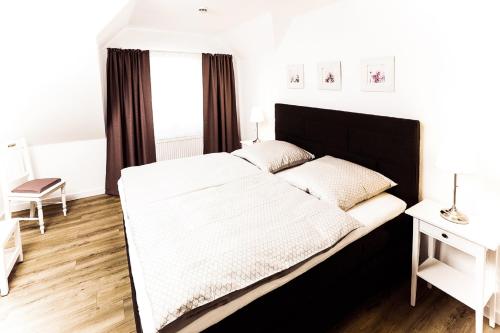 巴特塞森多夫Gästehaus Sam的一间卧室配有一张大床和黑色床头板