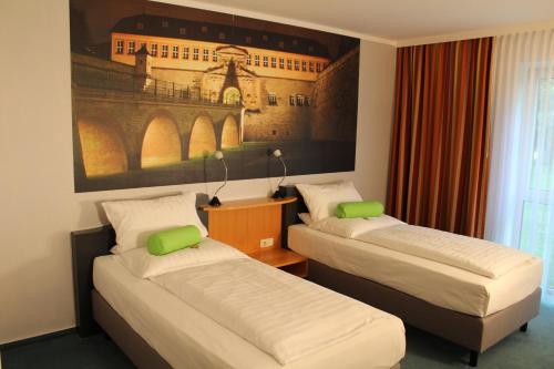 爱尔福特H爱尔福特酒店的一间设有两张床的客房,墙上挂着一幅画