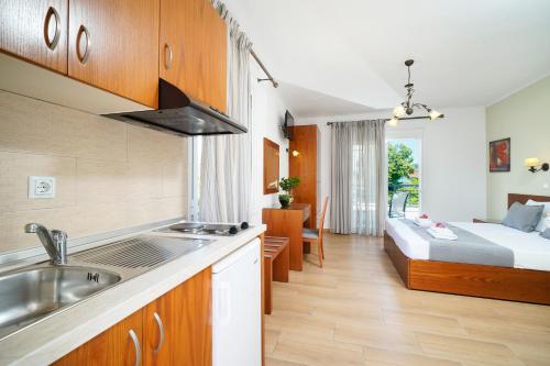 萨索斯Antigone Hotel的一个带水槽的厨房和一张位于客房内的床
