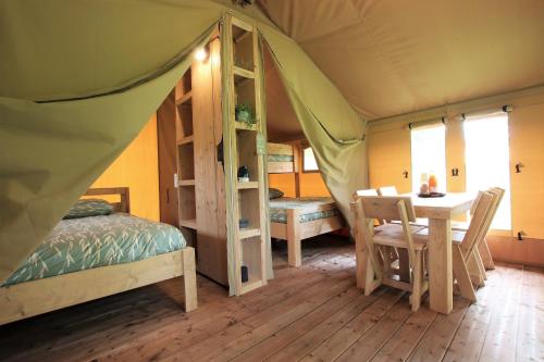 Tardets-SorholusTENTE SAFARI Lodge FERME CARRIQUE的一间卧室配有一张床,帐篷内配有一张桌子