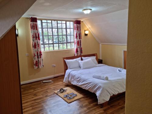 奈瓦沙Weavers Haven的一间卧室设有一张床和一个大窗户