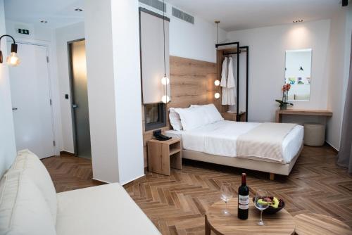 纳夫普利翁Liberty of Nafplio的酒店客房设有两张床和一张桌子,并配以一瓶葡萄酒