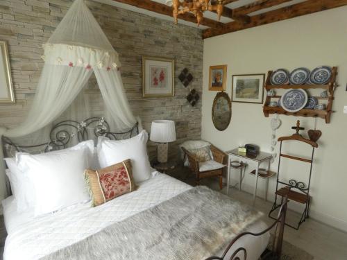 本拉提本拉提城堡马厩住宿加早餐酒店的卧室配有白色的床和砖墙