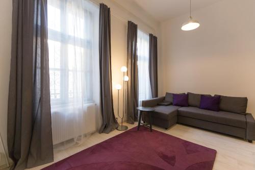 布达佩斯Palace District Apartment的带沙发和大窗户的客厅