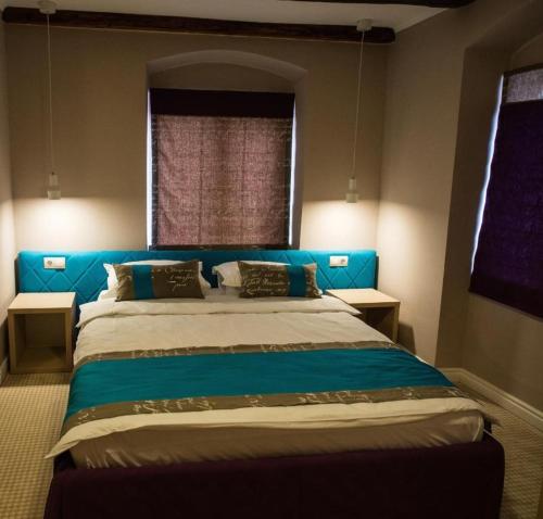 锡比乌CASA GRINDA的一间卧室配有蓝色的床和2个窗户