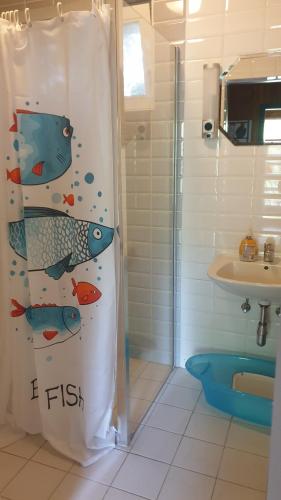 巴拉顿菲兹弗MiLa Home Balaton的浴室设有淋浴帘,上面有鱼