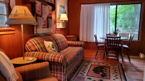 马吉谷Cozy Creek Cottages的客厅配有沙发和桌子