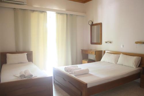 拉加纳斯MARIA STUDIOS LAGANAS的一间卧室配有两张带毛巾和镜子的床