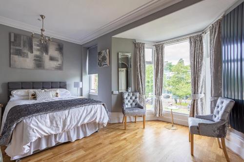 肯德尔Glenholmekendal的一间卧室配有一张床、两把椅子和一个窗户
