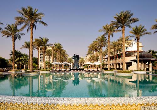 科威特Jumeirah Messilah Beach Kuwait的度假村内一座种有棕榈树的大型游泳池