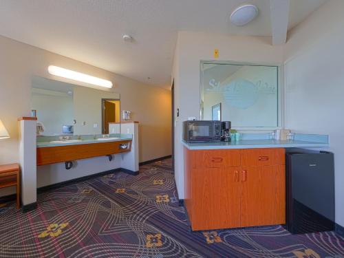 林肯市Siletz Bay Beachfront Hotel by OYO Lincoln City的酒店客房设有水槽和微波炉