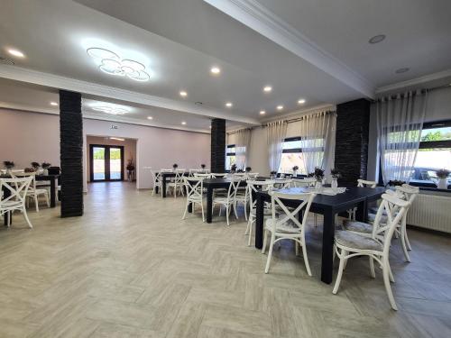 皮亚特拉-尼亚姆茨Pensiunea Lavanda, Piatra-Neamț的餐厅设有黑桌和白色椅子