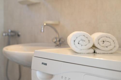 加藤扎克罗斯Anthia Apartment Sea View的浴室配有洗衣机上面的毛巾。