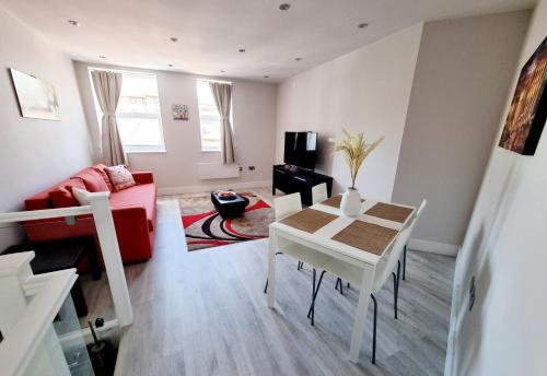 伯恩茅斯Modern Maisonette 2 Bedrooms Newly Renovated的客厅配有桌子和红色沙发