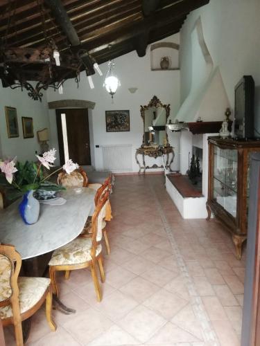罗西尼亚诺马里蒂莫Confortevole locale的客厅配有桌椅和壁炉