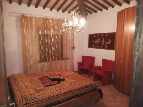 罗西尼亚诺马里蒂莫Confortevole locale的一间卧室配有一张床、吊灯和红色椅子
