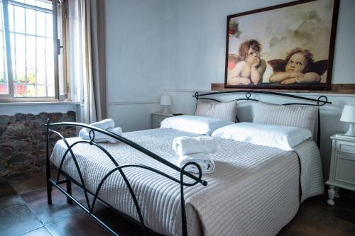 GuardialfieraIl Riparo的卧室配有一张床,墙上挂有绘画作品