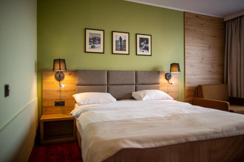 波伊亚纳内戈利Pensiunea La Bella Vista的一间卧室配有一张带两盏灯的大型白色床。