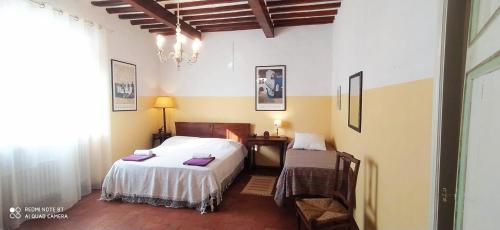 Matraiala stanza del sole的一间卧室配有一张床、一张桌子和一张四柱床。