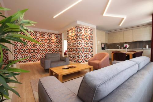 萨拉热窝萨拉热窝辉煌公寓酒店的客厅配有沙发、椅子和桌子