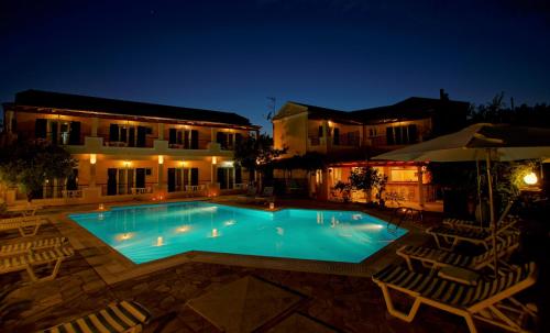 卡沃斯托尼的旅馆的一座带椅子的夜间游泳池和一座建筑