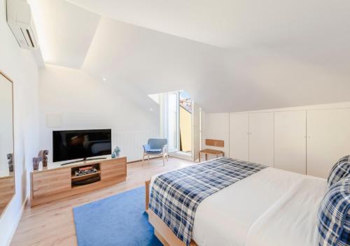 波尔图Mouzinho da Silveira Unique Apartments, by Oporto Collection的一间卧室配有一张床和一台平面电视