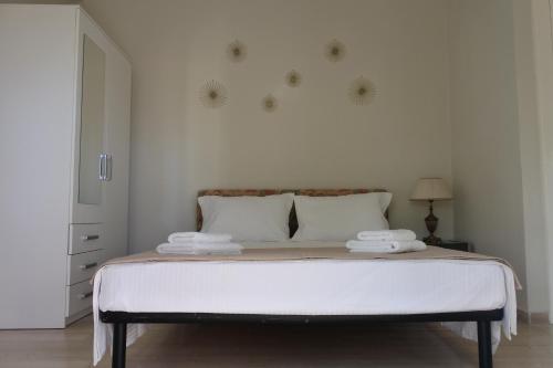 康托卡利Mina's serene garden house的白色卧室配有一张带两个枕头的大床