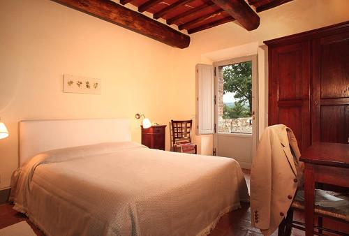 蒙塔尔奇诺Agriturismo Podere La Casa的一间卧室配有一张床、一张桌子和一个窗户。