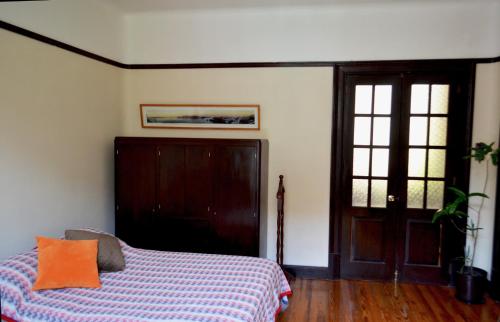 墨西哥城Bonita habitación en departamento compartido a dos calles del Zócalo CDMX的一间卧室配有一张带橙色枕头的床