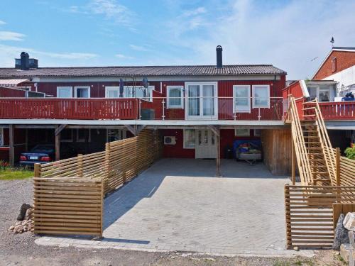 Hallstavik5 person holiday home in HALLSTAVIK的一座红色的大房子,前面有一个大院子