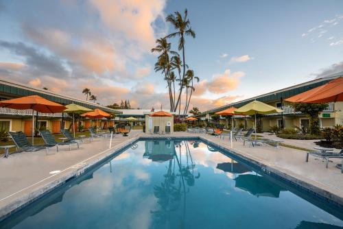 卡帕阿考伊海滩酒店的度假村的游泳池,配有椅子和遮阳伞