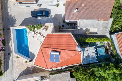 苏提万Villa Stone Pearl的享有带橙色屋顶和游泳池的房屋的顶部景致
