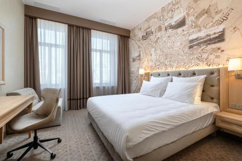 维尔纽斯CALVARY Hotel & Restaurant Vilnius的配有一张床和一张书桌的酒店客房
