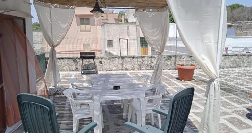 卡萨拉诺OLTREMARE casa per vacanze con terrazzo的庭院里的白色桌椅