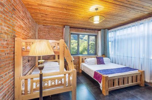 怀柔Beijing Mutianyu Great Wall Wangshanyuan Homestay的一间卧室配有两张双层床和一盏灯。