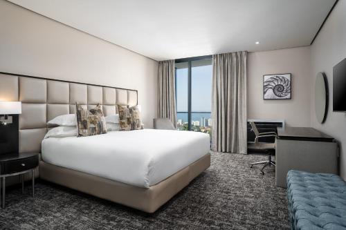 德班Premier Hotel Umhlanga的酒店客房设有一张大床和一张书桌。