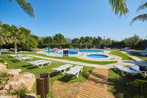 普拉德哈-德拉尔马德拉夫Alannia Costa Dorada的一个带白色椅子的公园和游泳池
