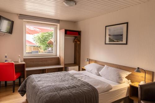 埃尔姆山麓克尼格斯卢特尔Hotel zur Post Ochsendorf的一间卧室设有一张床和一个窗口