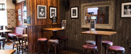 曼彻斯特The Spread Eagle的餐厅内带木墙和凳子的酒吧