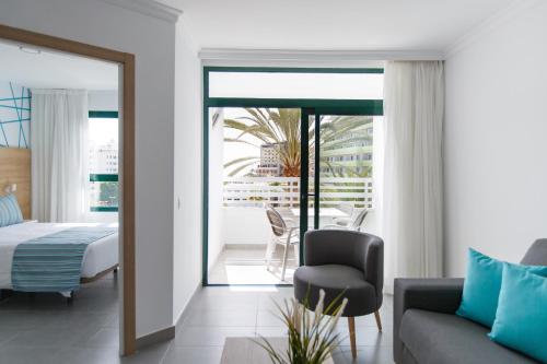 英格兰海滩奥索尔瓦尔哈拉公寓式酒店的一间卧室配有一张床、一张沙发和一把椅子