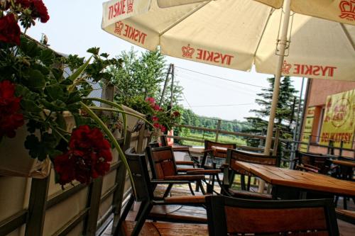 Horyniec"Aleksandrówka" Restauracja i Noclegi的一个带桌椅和遮阳伞的庭院
