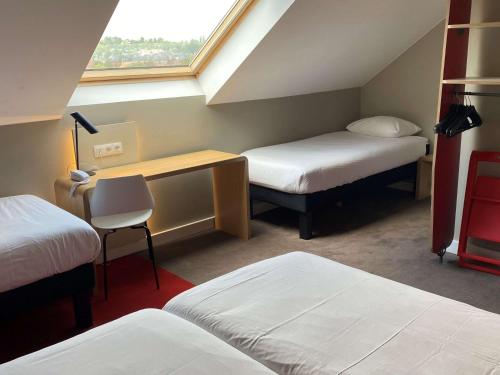 瓦夫尔瓦夫尔布鲁塞尔东宜必思酒店的客房设有两张床、一张桌子和一个窗户。